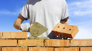 bricklayer laying bricks to make a wall