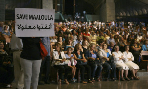 A Syrian woman holds a banner for saving Maaloula while Lebanese and Syrian Christian Maronites pray for peace in Syria, in Harisa, Jounieh