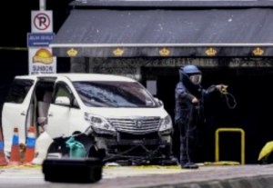 epa04437788 A member of a Malaysian bomb squad unit investigates the scene where a grenade exploded in Kuala Lumpur, Malaysia, 09 October 2014. One man was killed on 09 October and at least 13 other were injured in a grenade explosion in front of an entertainment centre in Kuala Lumpur, a police official said. The attack occurred before dawn in Jalan Bukit Bintang, a road lined with bars and other entertainment spots, said Khairi Ahrasa, Kuala Lumpur deputy police chief. Khairi said a second grenade, which did not explode, was recovered under a car parked on the street. He said a Thai national, a Singaporean and a Chinese tourist from mainland were among those injured. Home Minister Jnaidi Jaafar said the police was looking into several possible suspects in the blast. Several cars parked in the street were damaged by the blast, according to the police investigator.  EPA/STR