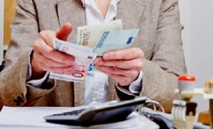 Bankkauffrau zählt Geld am Schreibtisch