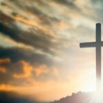 12469-jesus-cross-on-hilltop-sunrays-at-dusk-gettyi